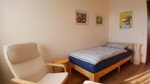 a small bedroom with a bed and a chair at Ferienwohnung Feld und Wiese in Höxter +24 photos