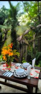 a wooden table with plates and utensils on it at Villa Secret Stream in Mirissa