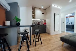 a kitchen and living room with a bar and stools at KNB City Suites in Odorheiu Secuiesc