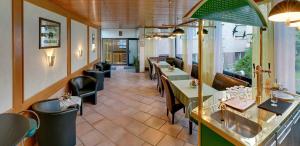 a restaurant with tables and chairs in a room at Hotel Keinath Stuttgart in Stuttgart