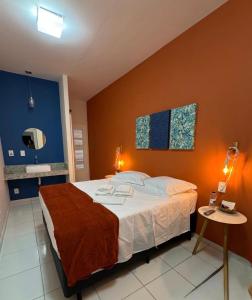 a bedroom with a large bed and a table at Pousada Sete Colinas in Bragança Paulista