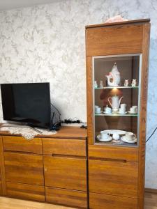 a wooden cabinet with a television on top of it at Debreceno apartamentai in Klaipėda