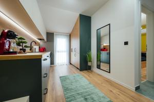 a kitchen with green and white walls and a green rug at KNB City Suites in Odorheiu Secuiesc