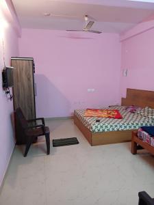 a bedroom with two beds and a chair in it at Roamwander doublerooms in Vagamon