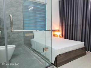 a bathroom with a bed and a glass shower at GolDen RiCe in Thái Thụy