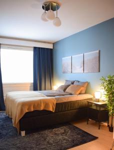 a bedroom with a large bed with blue walls at Tilava ja elegantti kolmio in Kokkola