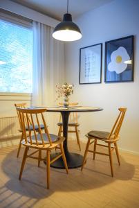 a dining room with a table and two chairs at Tilava ja elegantti kolmio in Kokkola +14 photos