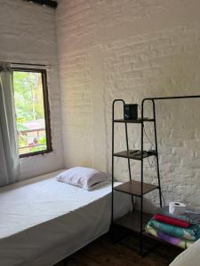 a small bedroom with a bed and a shelf at hospedaje ecopolis birds in El Queremal