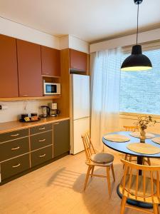 a kitchen with a table and chairs and a refrigerator at Tilava ja elegantti kolmio in Kokkola