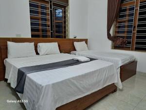two beds with white sheets in a room at GolDen RiCe in Thái Thụy +13 photos