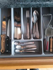 a tray filled with utensils in a drawer at Debreceno apartamentai in Klaipėda