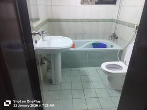 a bathroom with a sink and a toilet and a tub at OST Homes Rolla Park in Sharjah +18 photos