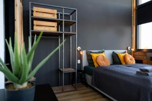 a bedroom with a bed and a plant in it at Brouwersdam Stay in Ouddorp