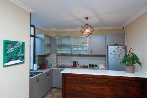 eine Küche mit weißen Schränken und einem Kühlschrank in der Unterkunft Syune Mini Hotel in Gjumri + 48 Fotos