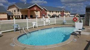 a small pool with chairs and a white fence at Americas Best Value Inn and Suites - Nevada in Nevada