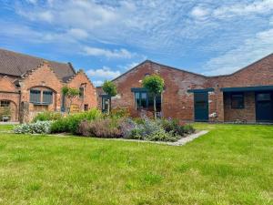 a brick house with a lawn in front of it at Courtyard View in Ashbourne