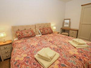 a bedroom with a large bed with two towels on it at Courtyard View in Ashbourne