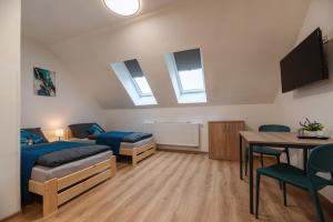a bedroom with a bed and a desk and a table at Apartmány Dalešice in Dalešice
