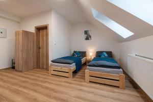 a bedroom with two beds and a skylight at Apartmány Dalešice in Dalešice
