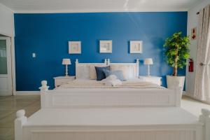 a bedroom with a white bed with a blue wall at Paternoster Lodge in Paternoster +64 photos