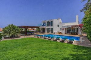 a house with a swimming pool and a yard at Villa Sargantana Negra in Binibeca
