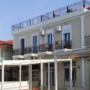 a white building with a balcony on top of it at Mateo Rooms in Himare