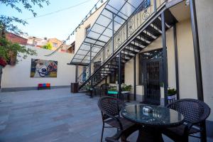 eine Terrasse mit Tisch und Stühlen vor einem Gebäude in der Unterkunft Syune Mini Hotel in Gjumri