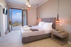 a bedroom with a large bed and a balcony at Vasilikades by Vintage Travel in Fiskardo