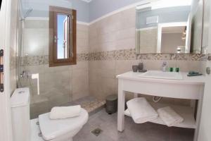a bathroom with a sink and a toilet and a shower at Vasilikades by Vintage Travel in Fiskardo +12 photos