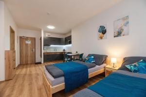 a bedroom with two beds and a kitchen at Apartmány Dalešice in Dalešice
