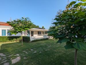 a house with a tree in the yard at Къщички Морски Светулки in Sinemorets