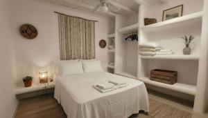 a white bedroom with a bed with towels on it at Stunning Sea-View Villa w Access to Shared Pools in Mikonos