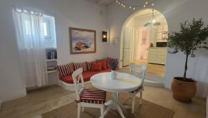 a living room with a table and a couch at Stunning Sea-View Villa w Access to Shared Pools in Mikonos