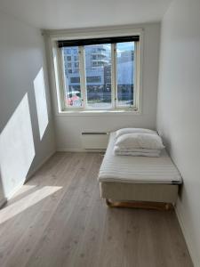 an empty room with a bed and a window at Nobelgården in Harstad