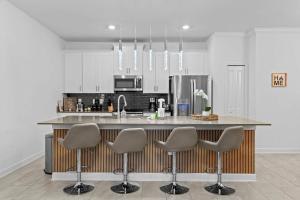 a kitchen with a counter with four stools at Special 4bedroom TH w-private pool next to Disney in Kissimmee