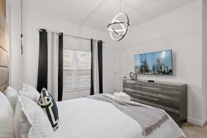 a bedroom with a bed and a flat screen tv at Special 4bedroom TH w-private pool next to Disney in Kissimmee +39 photos