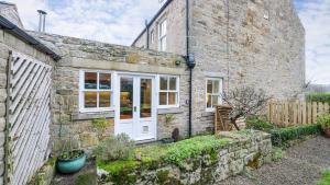 an old stone house with a white door at Summers Nook in Humshaugh