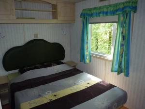 a bed in a small room with a window at ZEcamping 3 étoiles animaux acceptés tennis piscine et soirées animées in Pézuls