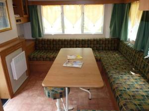 a room with a table and a couch with a window at ZEcamping 3 étoiles animaux acceptés tennis piscine et soirées animées in Pézuls