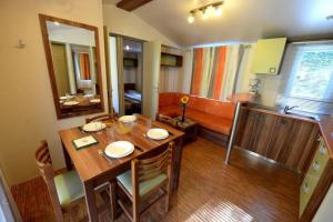 a dining room with a table and a couch at ZEcamping 4 étoiles familial animaux acceptés animé équitation in Saint-Rome-de-Tarn