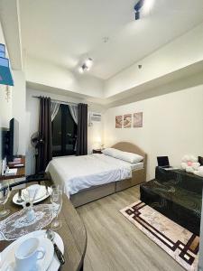 a bedroom with a bed and a table with dishes on it at Peaceful Studio at The Median - City Skyline View, Short Walk to IT Park in Cebu City +19 photos