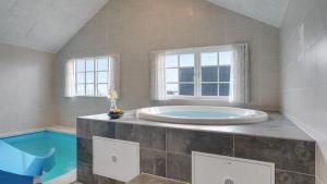 a large bathroom with a tub and a swimming pool at Villavilla 520 - Mommark, Sydjylland in Sarup