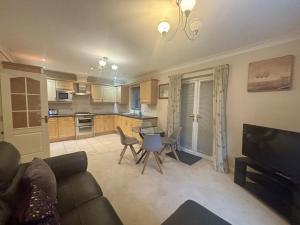 a living room with a couch and a kitchen at Bracknell Spacious 2 Bedroom Apartment in Bracknell