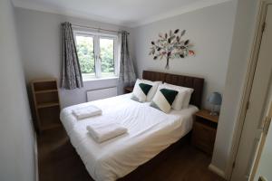 a bedroom with a bed with white sheets and pillows at Bracknell Spacious 2 Bedroom Apartment in Bracknell