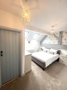a bedroom with a bed and a chandelier at Charming 2 bed cottage in Milcote Station