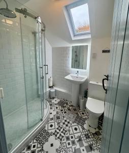 a bathroom with a shower and a toilet and a sink at Charming 2 bed cottage in Milcote Station