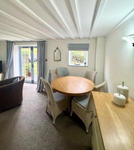 a dining room with a wooden table and chairs at Charming 2 bed cottage in Milcote Station