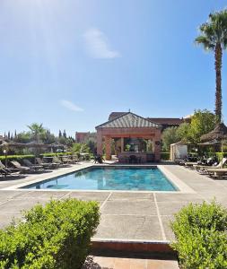 a swimming pool in a resort with a gazebo at Riad Mhidou in Marrakesh