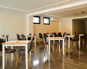 a room with tables and chairs and windows at Gaivota Guest House in Ponta Delgada