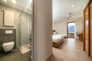 a bedroom with a bed and a shower and a bathroom at Hotel Deva in Riva del Garda
